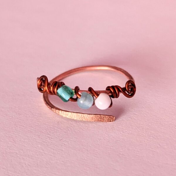 Solid Copper Ring with wire wrapped beads and hammered texture on soft pink background